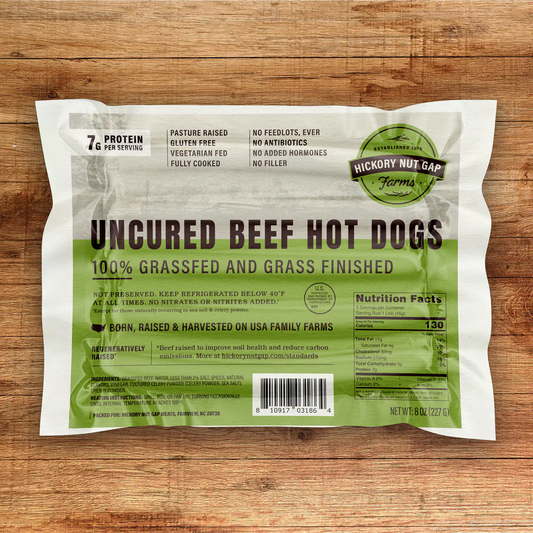 Package of uncured beef hot dogs with Hickory Nut Gap Farms branding on a wooden surface